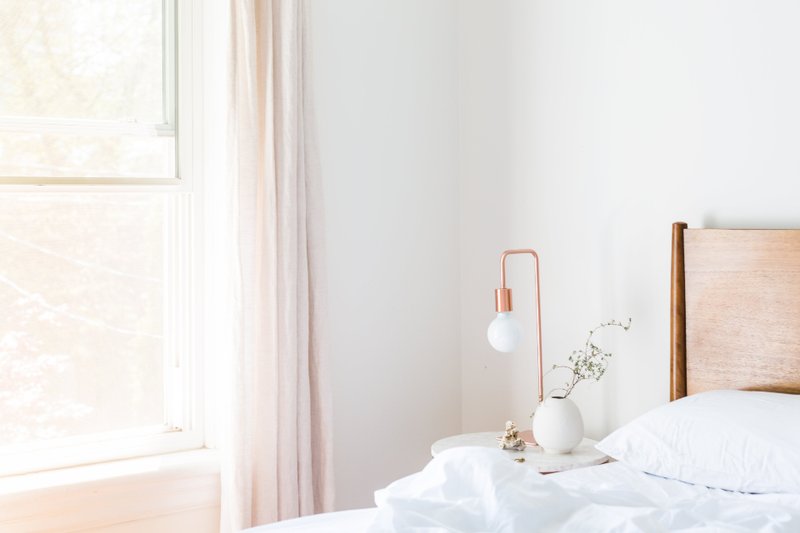 White pillows on a bed beside a sunlit window