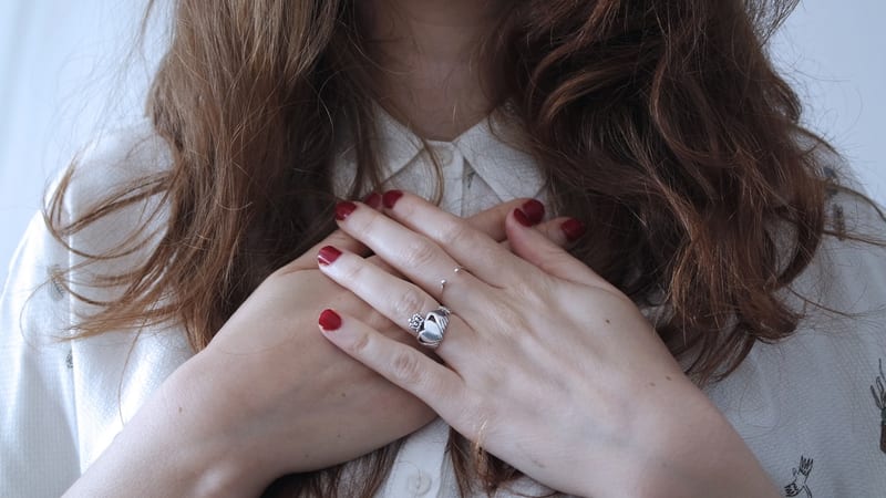 A woman resting her hands over her chest