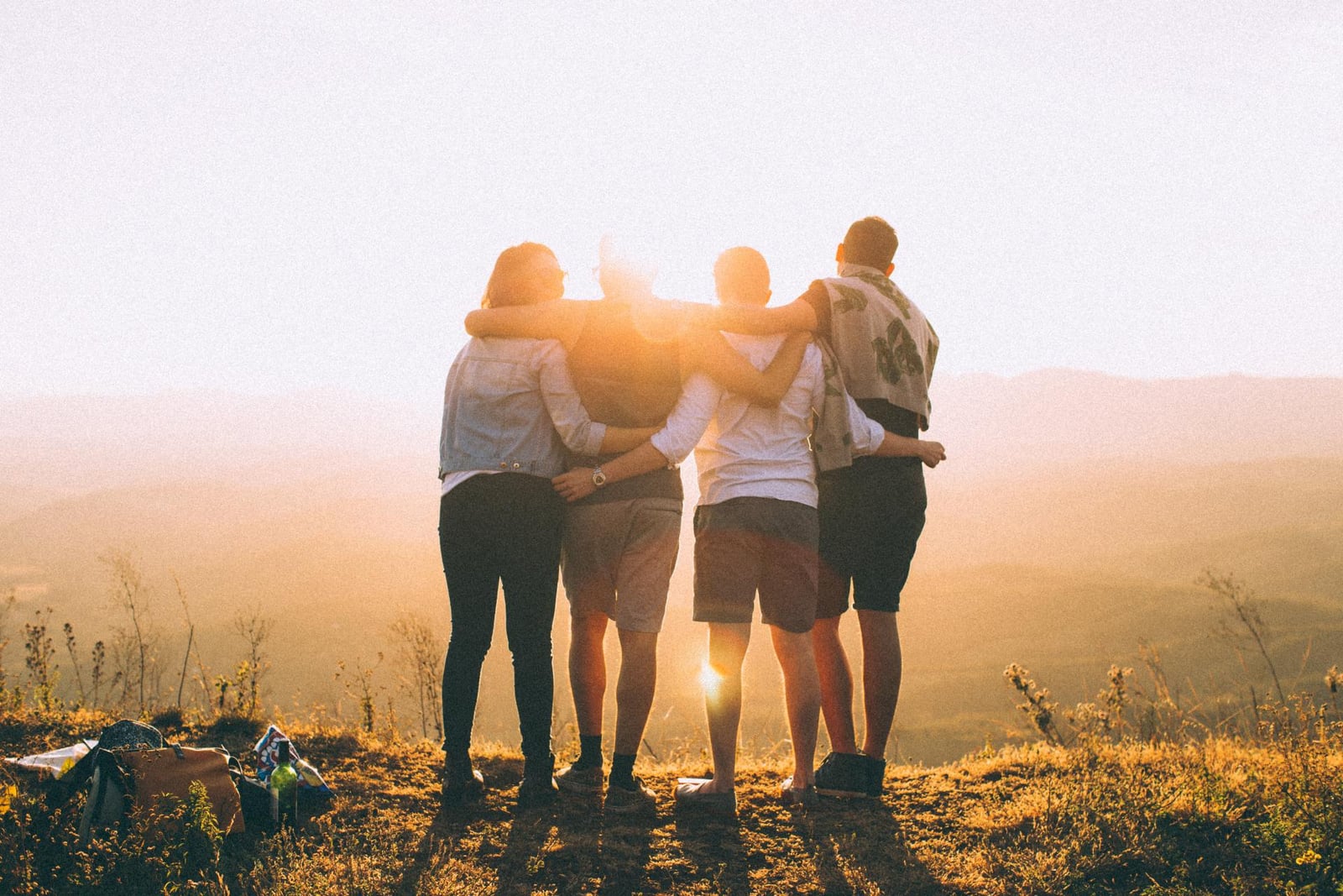A group of friends standing together at sunset
