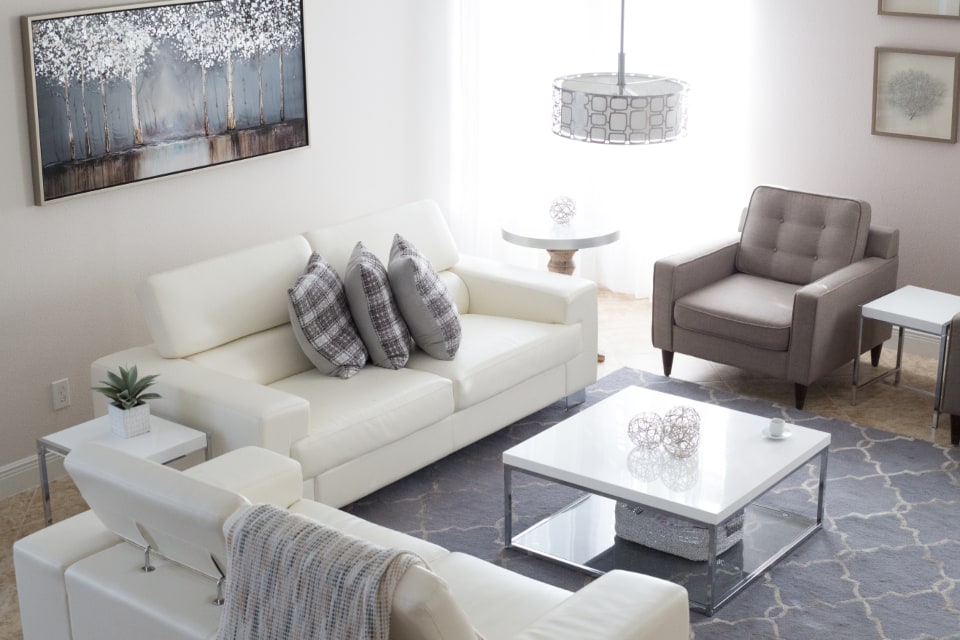 White sofas and a grey armchair in a bright living room