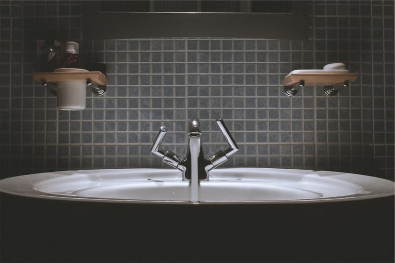 Two washbasins with taps and wall-mounted soap dispensers