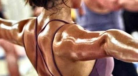 A person perspiring during exercise, seen from behind with arms outstretched