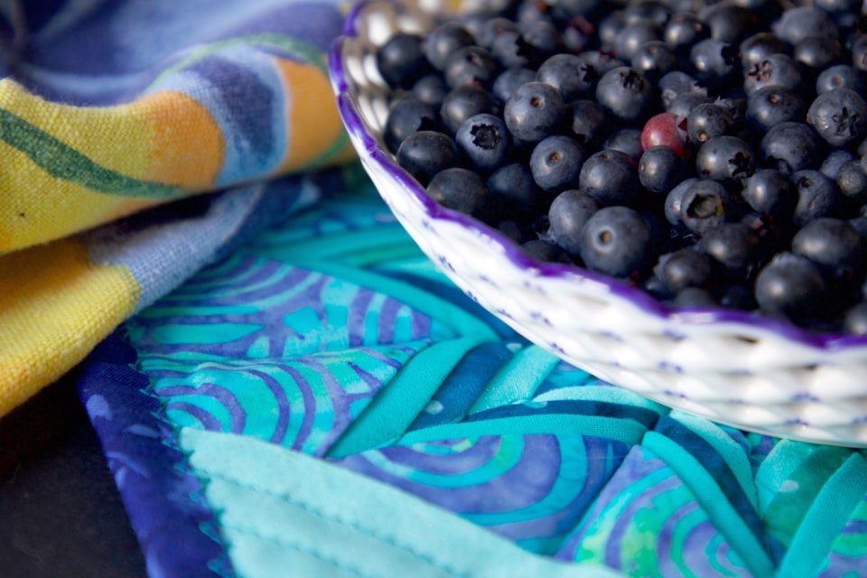 Fresh blueberries in a bowl on a patterned cloth