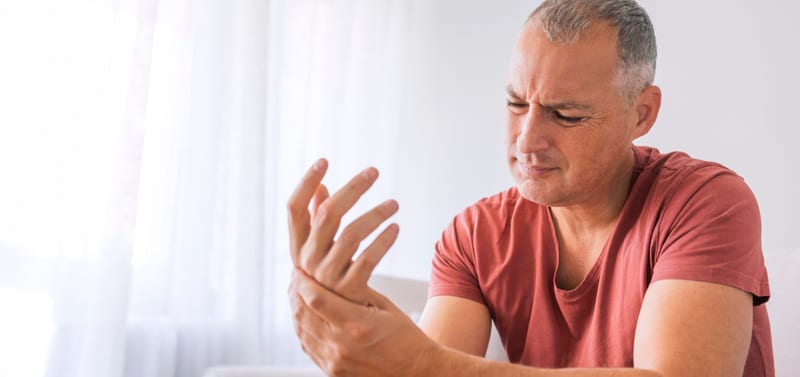 A man looking at his hand while seated